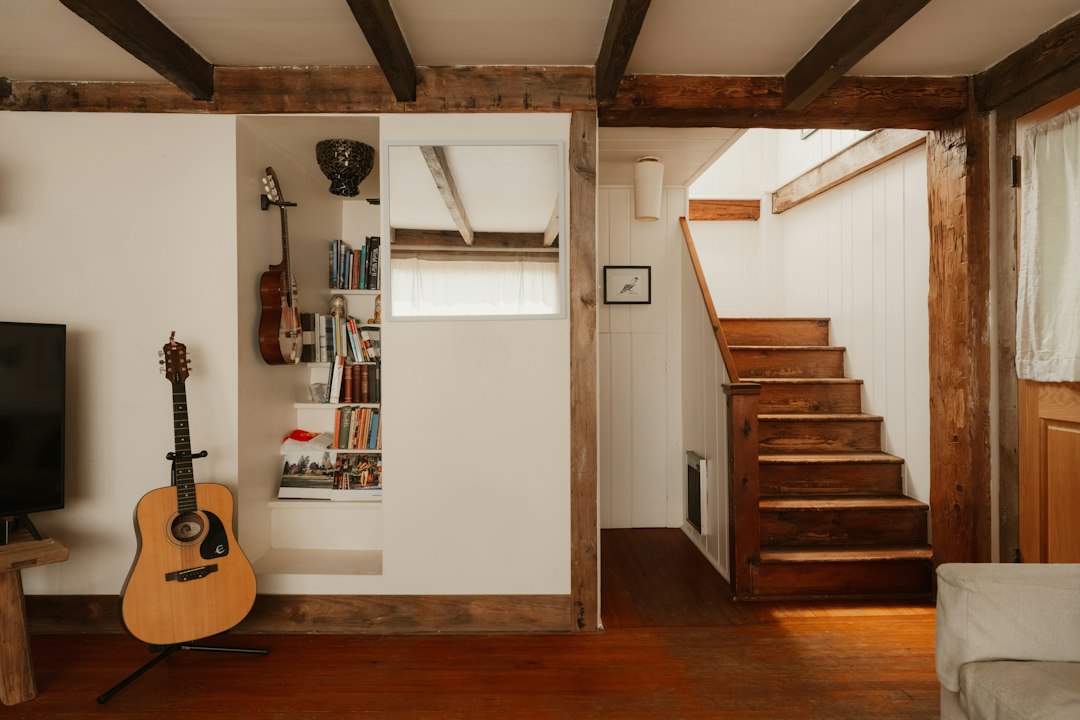 Interior de una vivienda con elementos de madera y acceso a la planta superior